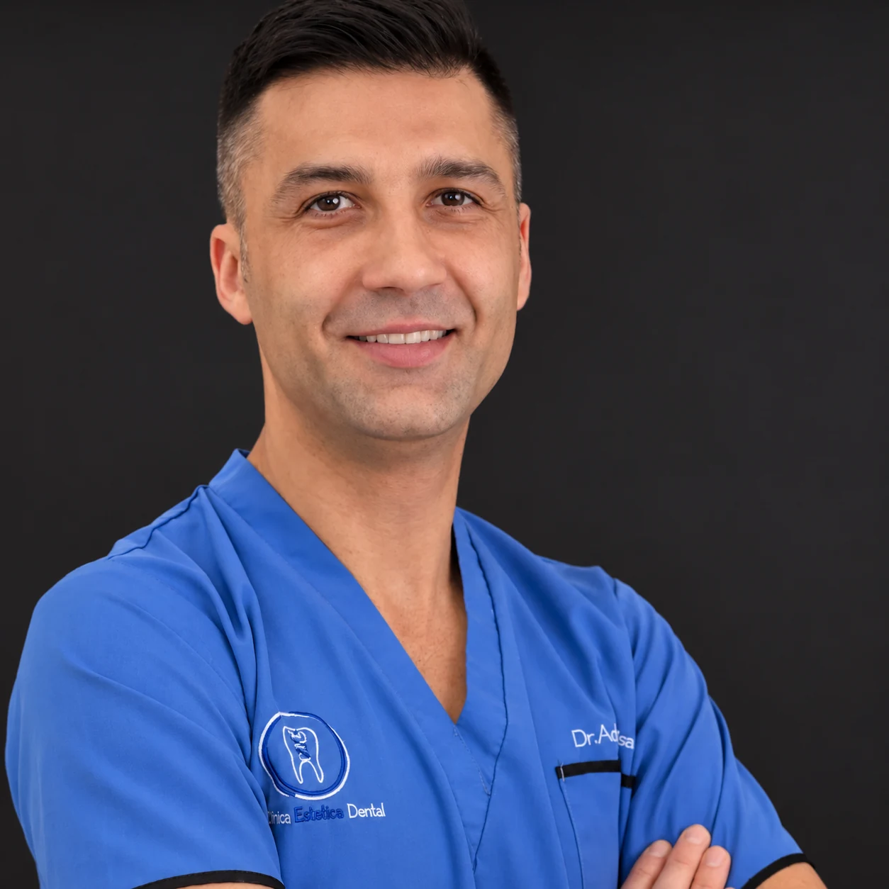 Dr. Adrian Moisa wearing blue clinical scrubs